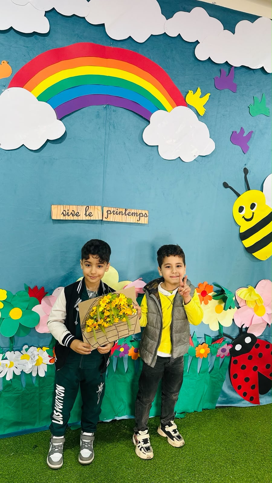 Deux élèves célébrant Vive le Printemps avec un bouquet de fleurs